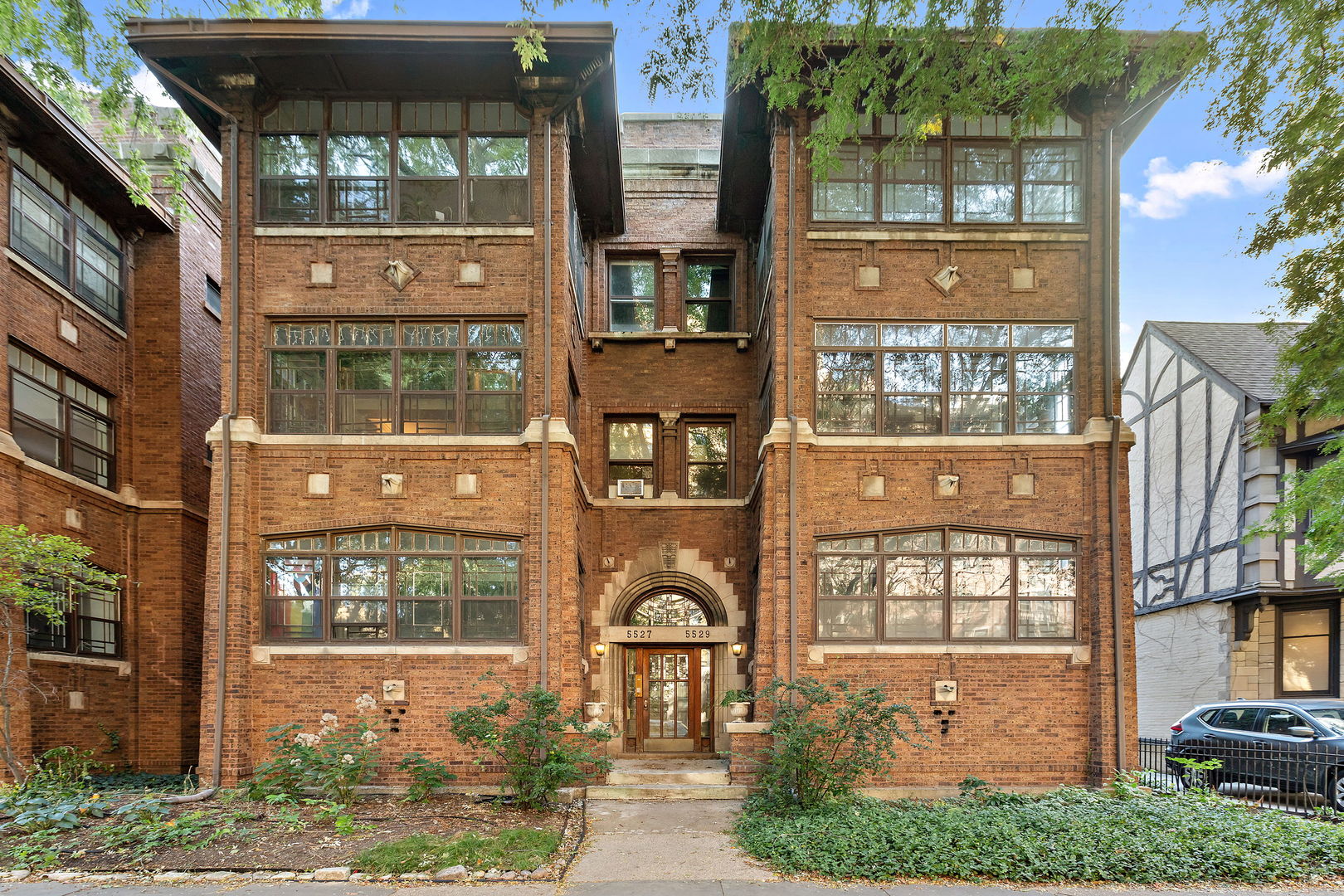 a front view of a residential apartment building with a yard