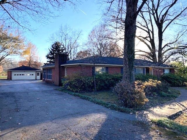 a view of a house with a yard and tree s