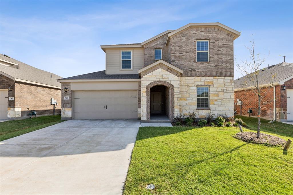 a front view of a house with a yard and garage