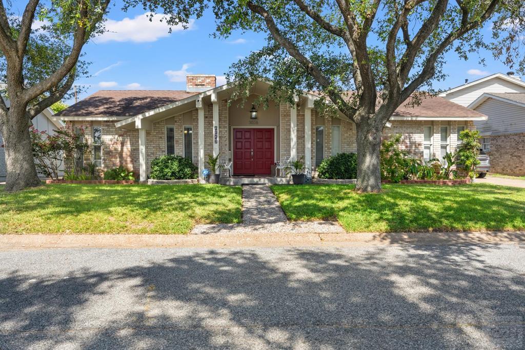 a view of a house with a tree in front of it