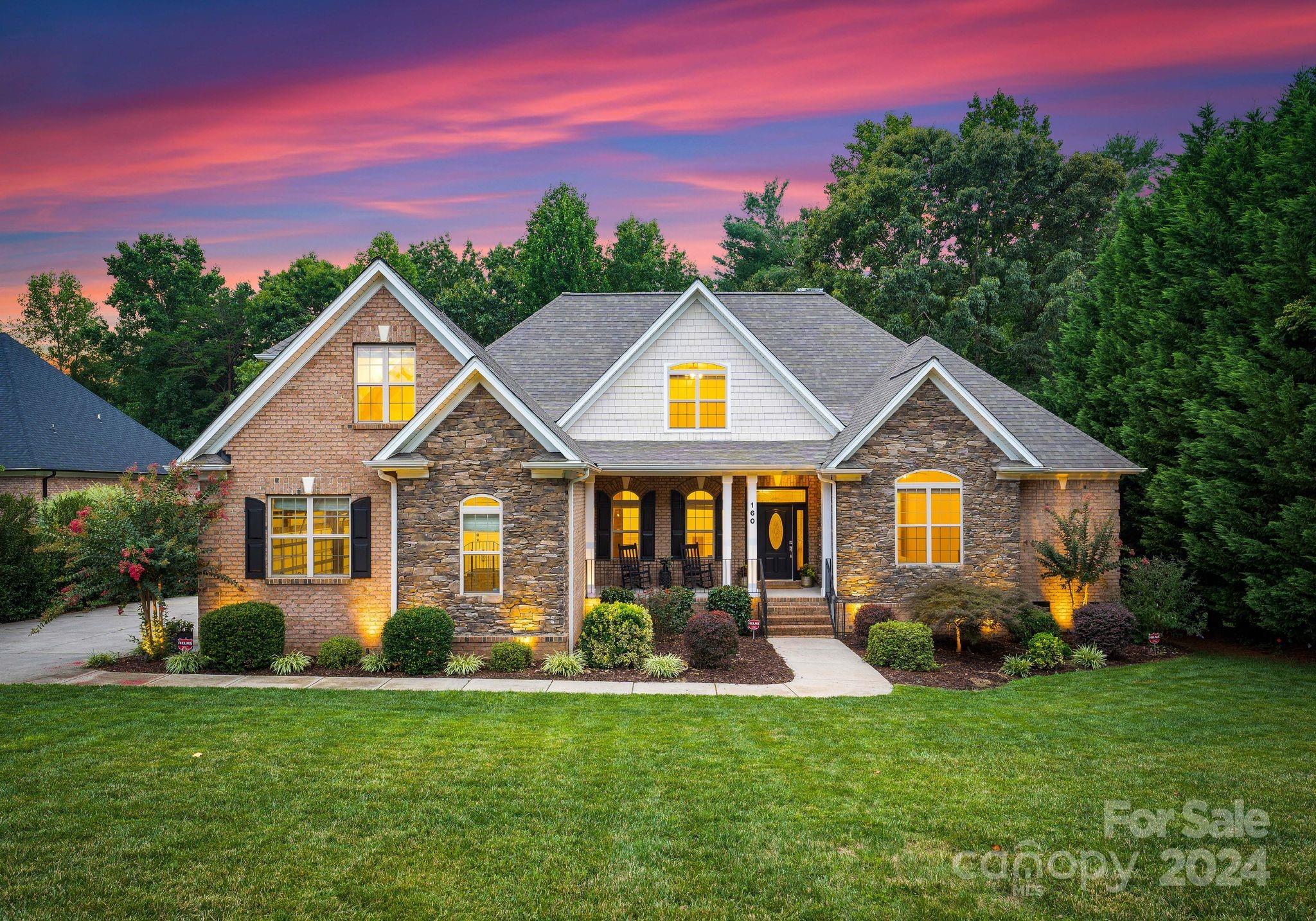 a front view of a house with a yard and trees