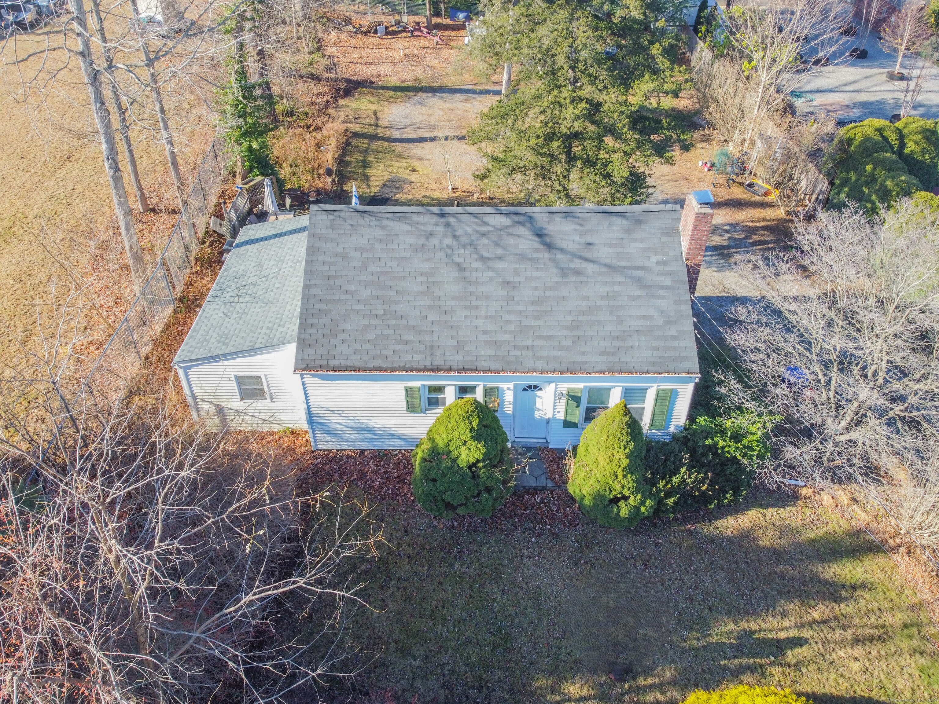 an aerial view of a house with large trees and plants