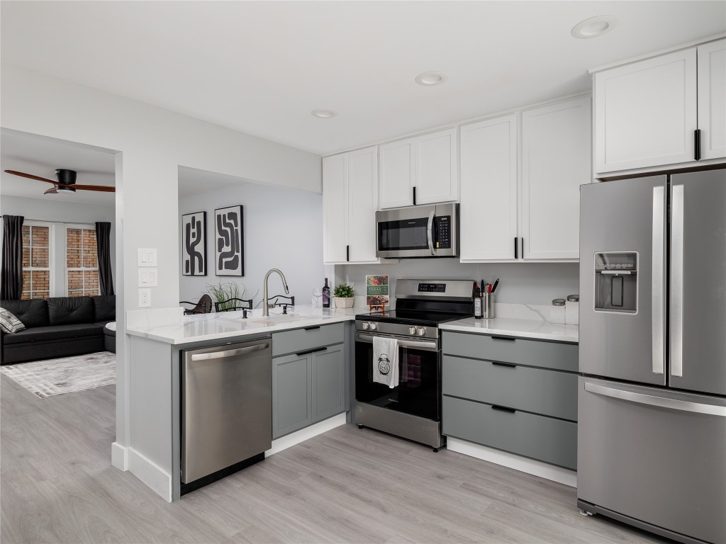 a kitchen with a sink white cabinets and stainless steel appliances