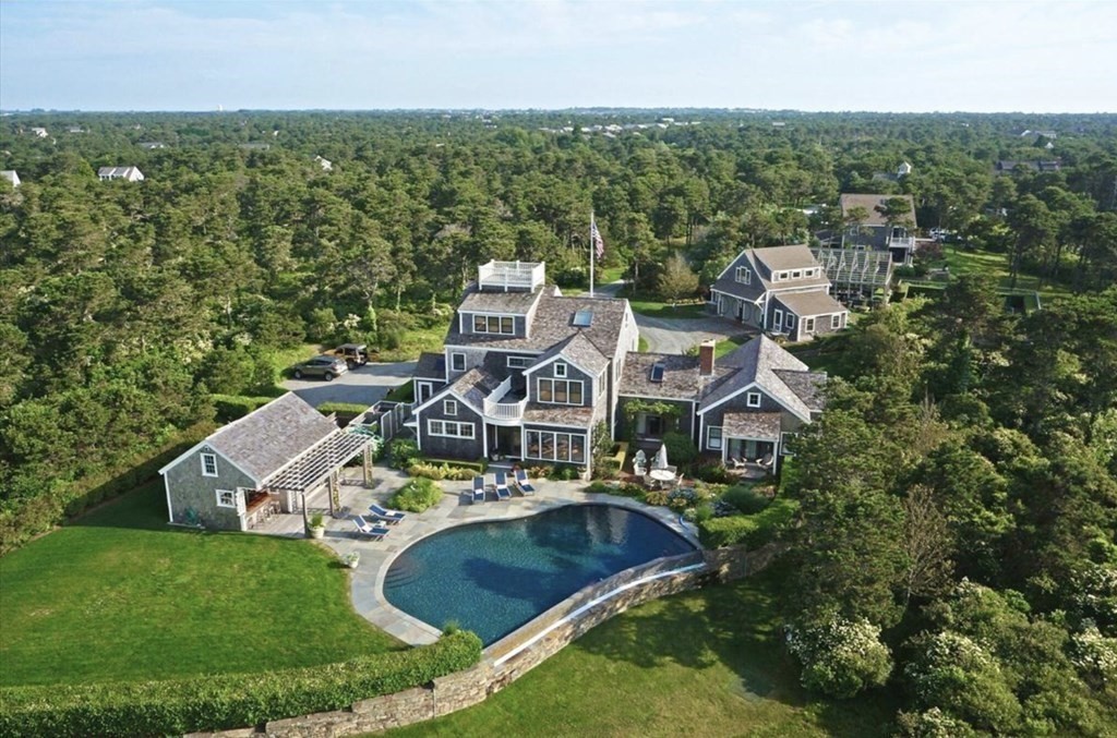 an aerial view of residential houses with outdoor space and trees