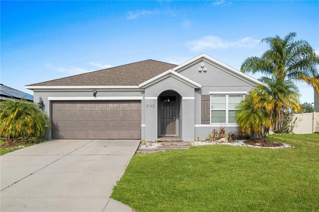 a front view of a house with a yard and garage