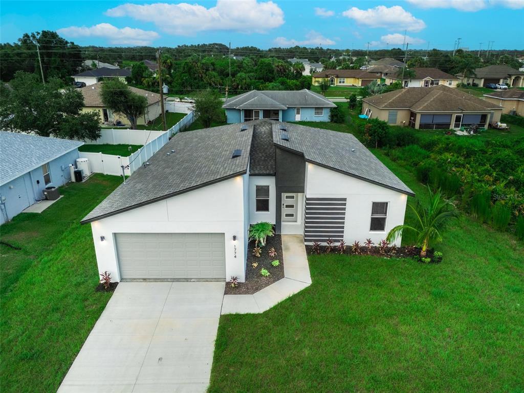 aerial view of a house with a yard and trees