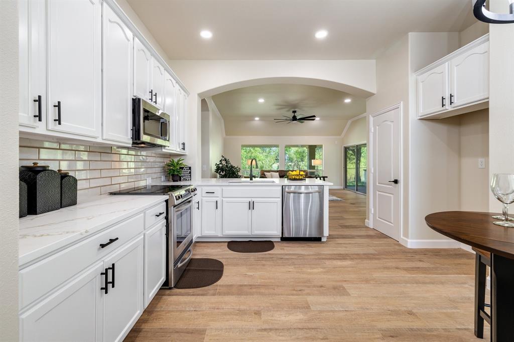 a kitchen with stainless steel appliances kitchen island granite countertop a refrigerator and a stove top oven