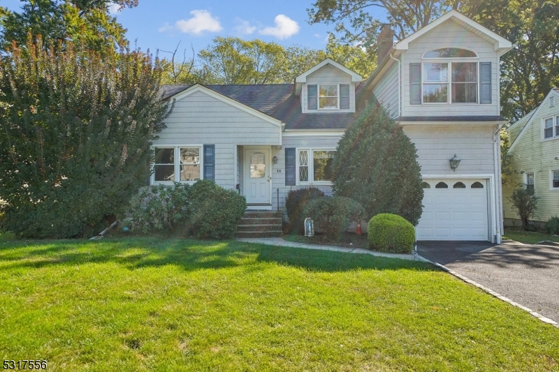 a front view of house with yard and trees in the background