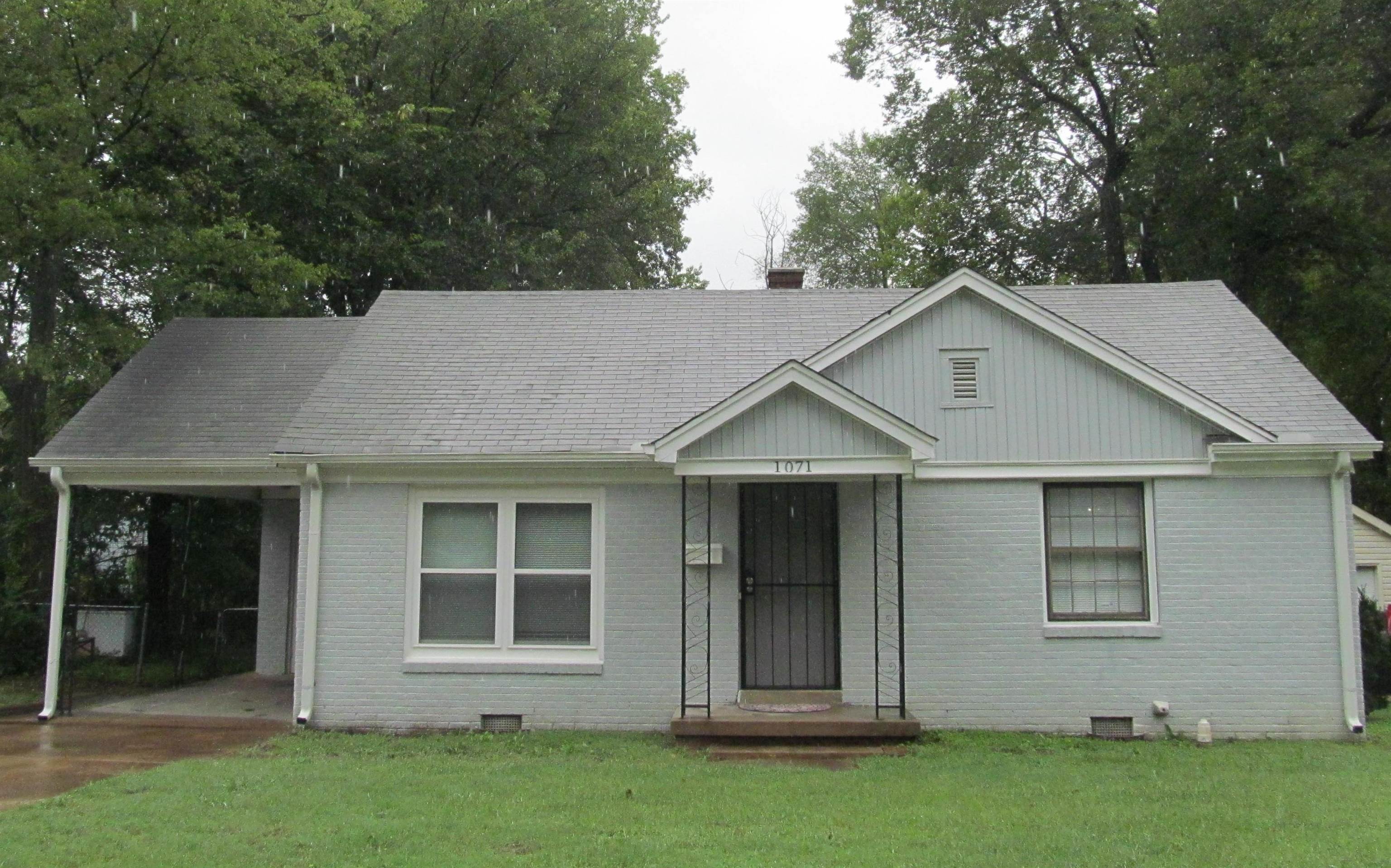 View of front of home with a front lawn and a carport