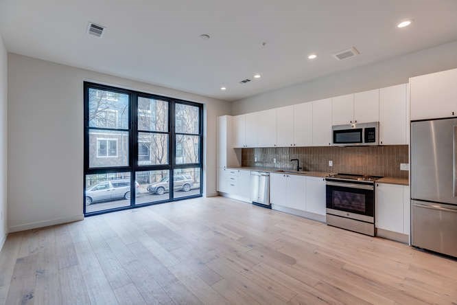 a large kitchen with stainless steel appliances granite countertop a stove and a refrigerator