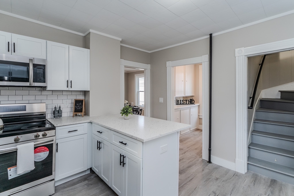 a kitchen with white cabinets and appliances