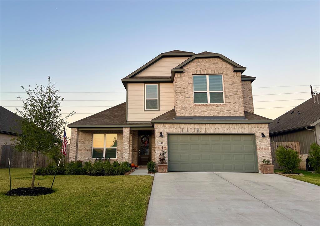 a front view of a house with a yard and garage