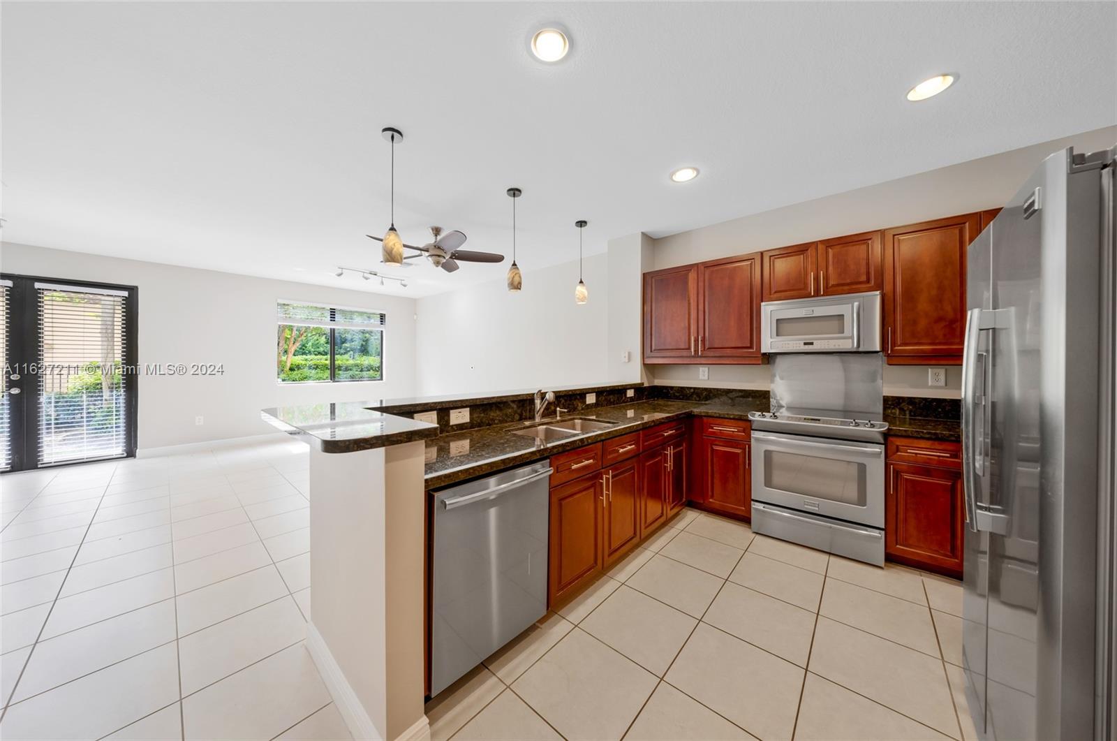 a kitchen with stainless steel appliances granite countertop a stove sink and cabinets