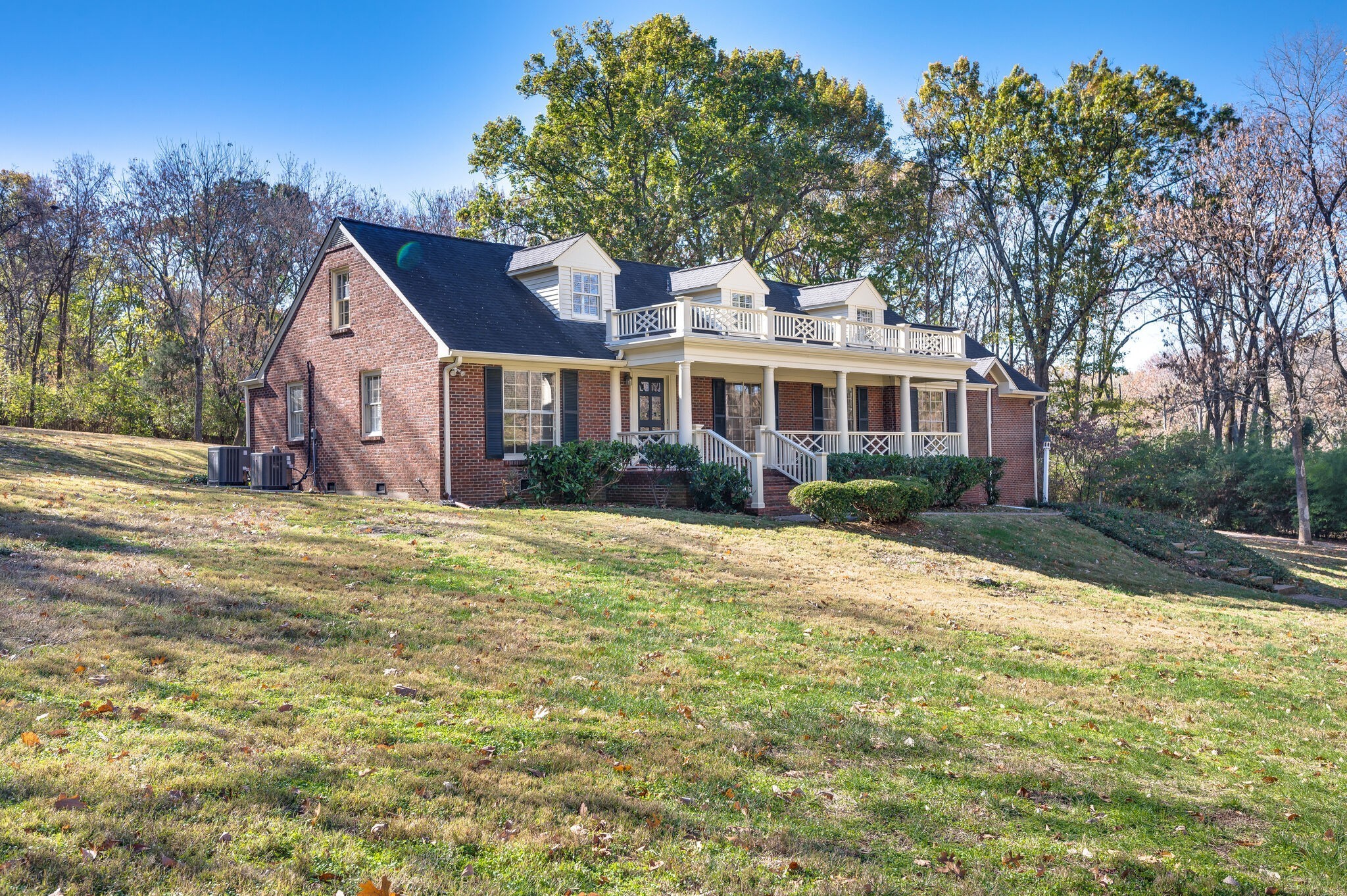 a front view of house with yard and trees around