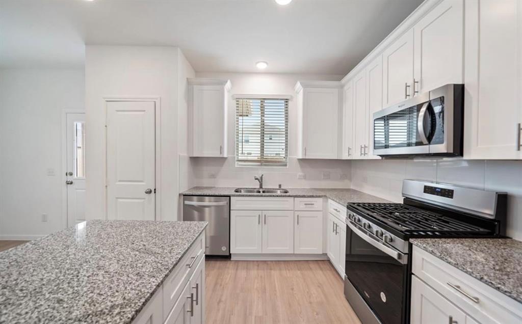 a kitchen with stainless steel appliances granite countertop wooden cabinets and a stove top oven