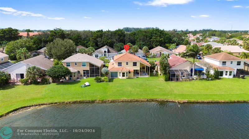 a aerial view of a house with garden and lake view