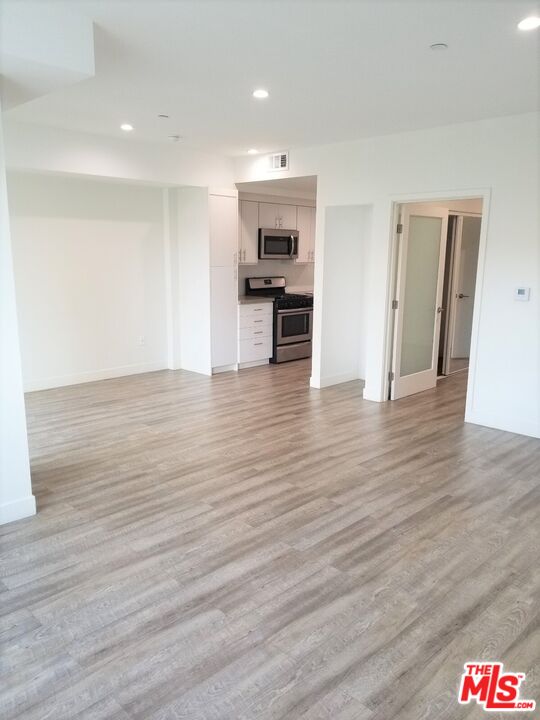 a view of a hallway with wooden floor