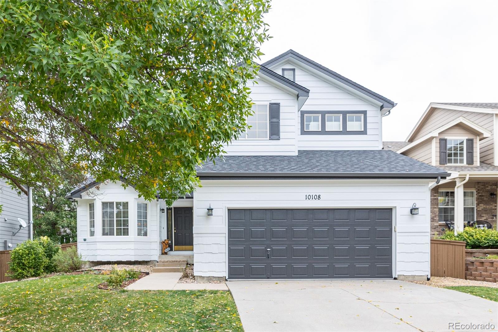 a front view of a house with a yard and garage