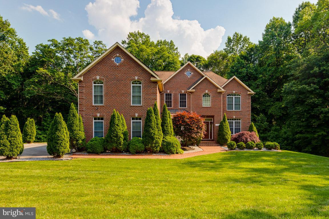 a front view of house with yard and green space