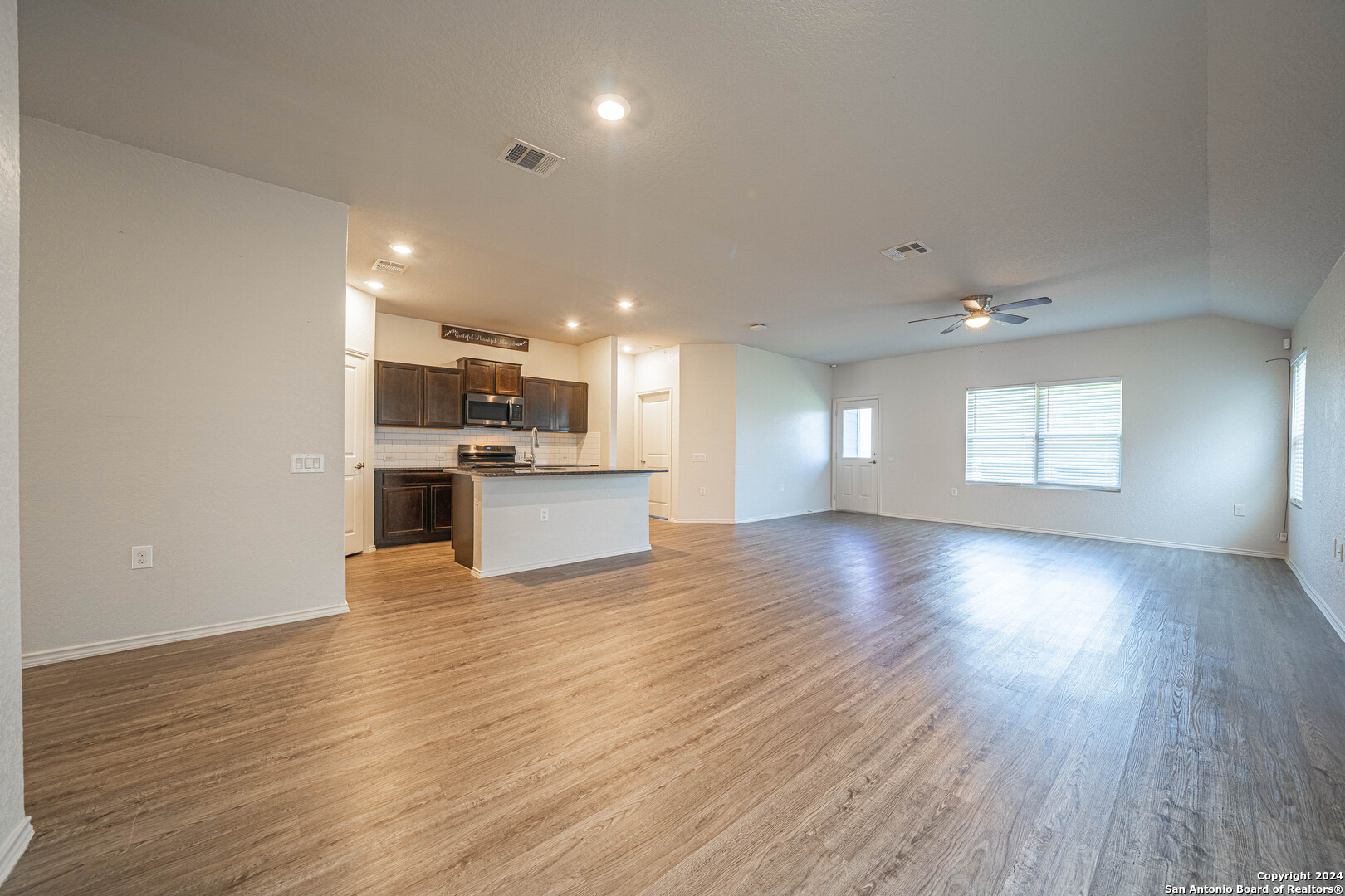 a view of kitchen and hall with wooden floor