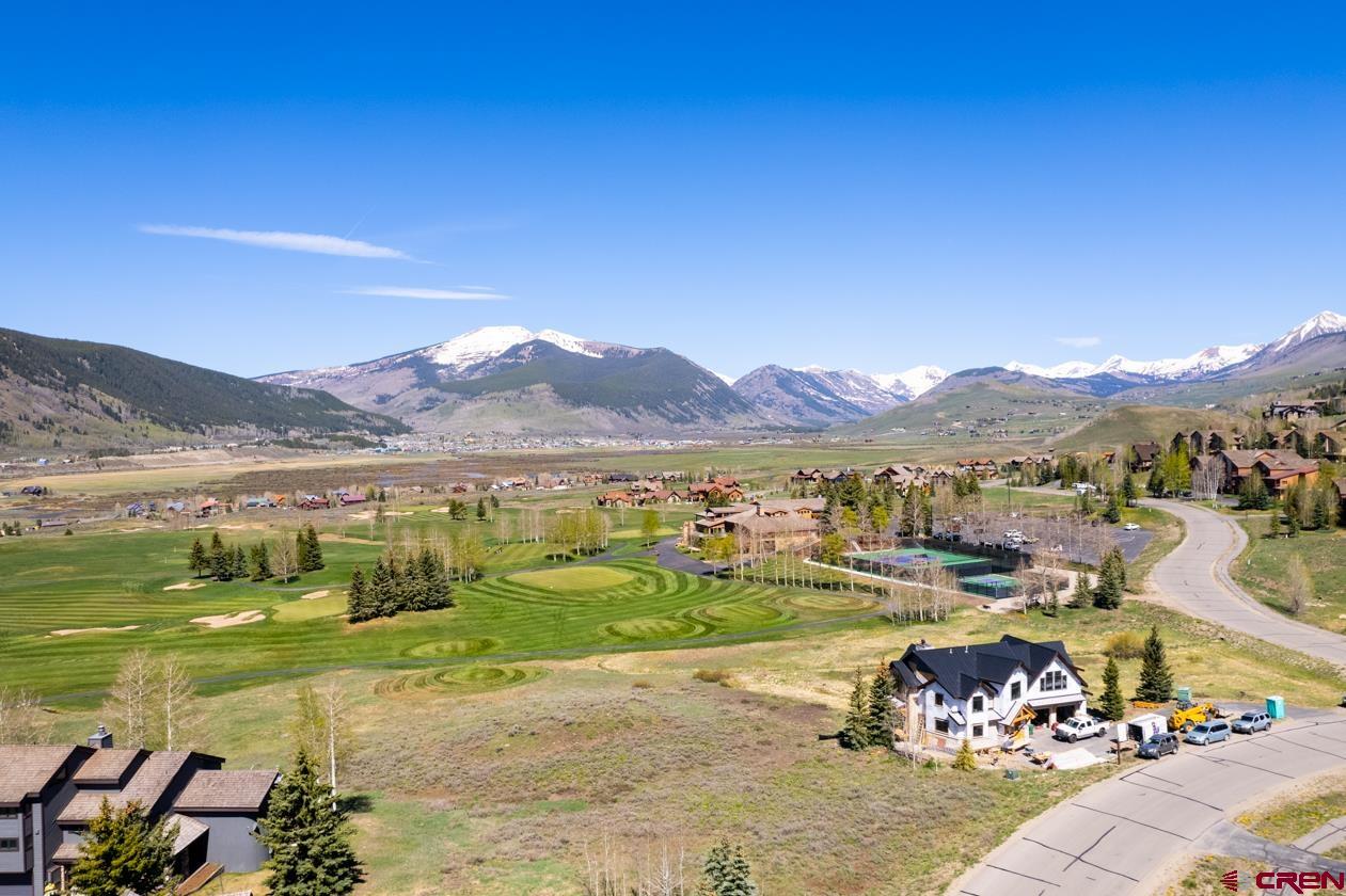 an aerial view of a town with swimming pool and mountains