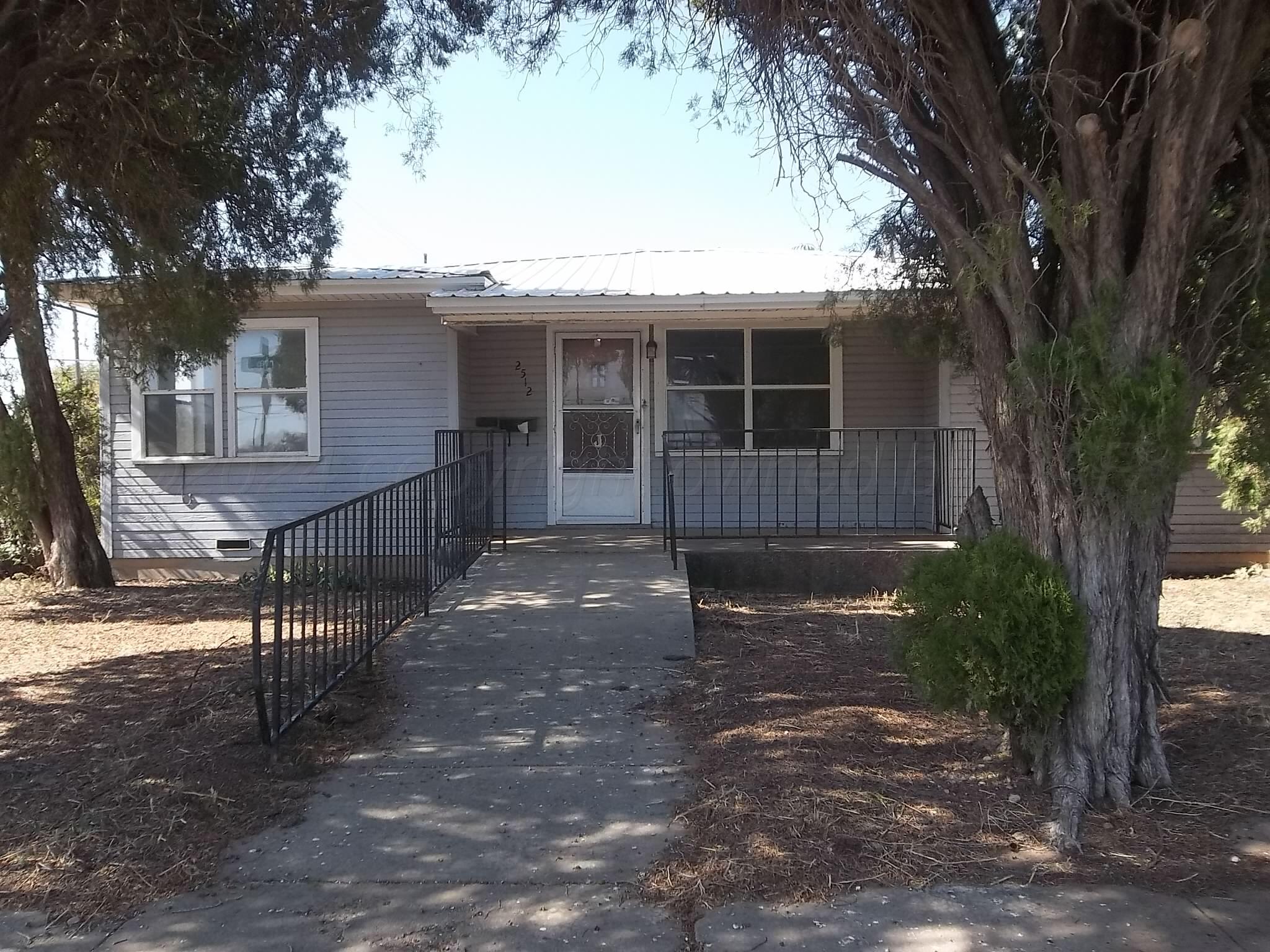 a view of a house with backyard and tree