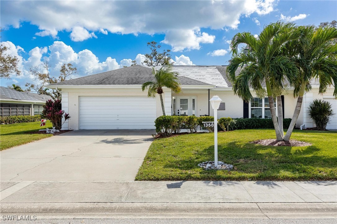 a view of a house with a yard and a garage