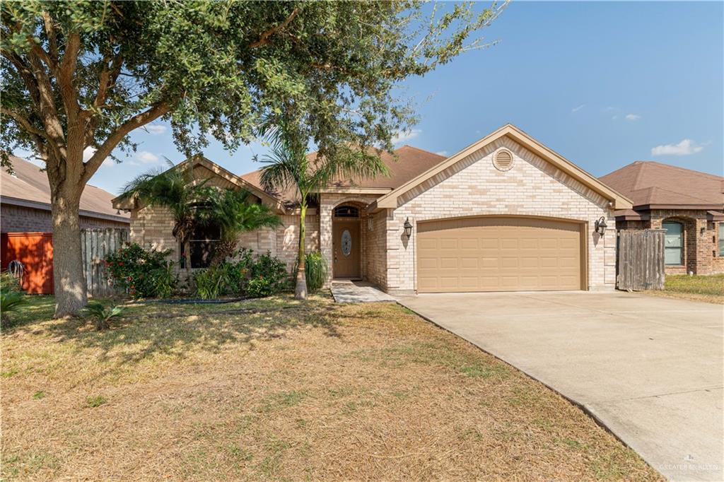 View of front of property with a front yard and a garage