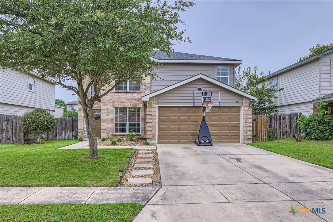 a view of a house with a yard and pathway