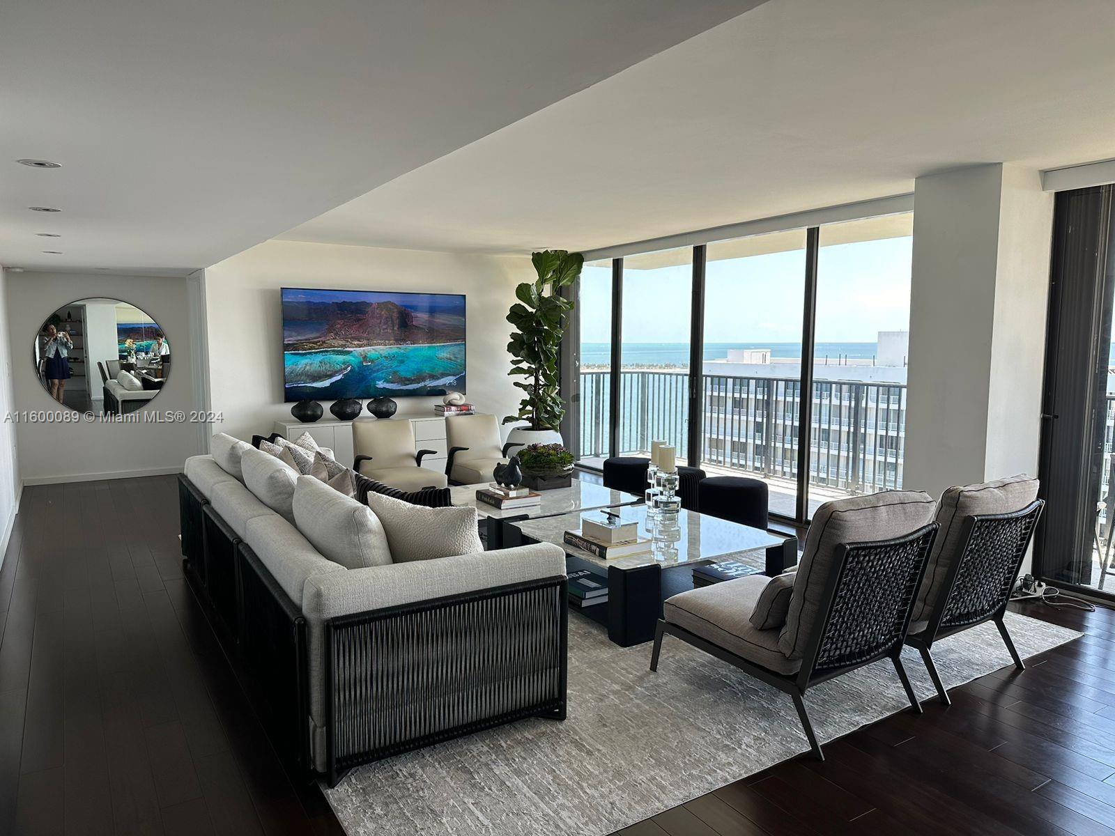 a living room with furniture large windows and a flat screen tv