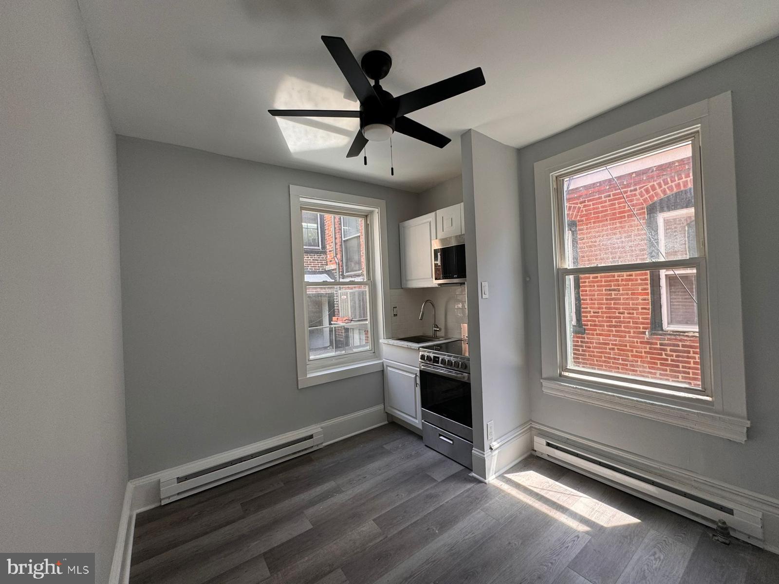 a living room with stainless steel appliances furniture and a window