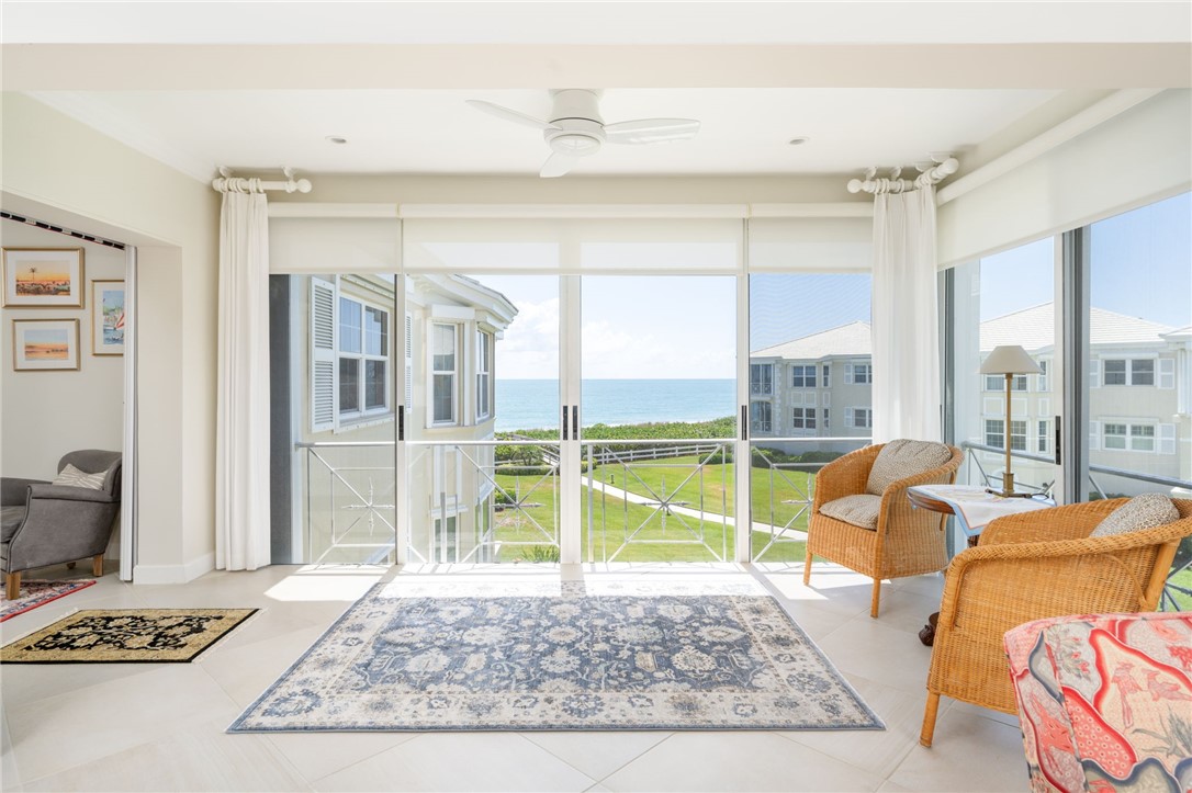 a living room with furniture and a floor to ceiling window