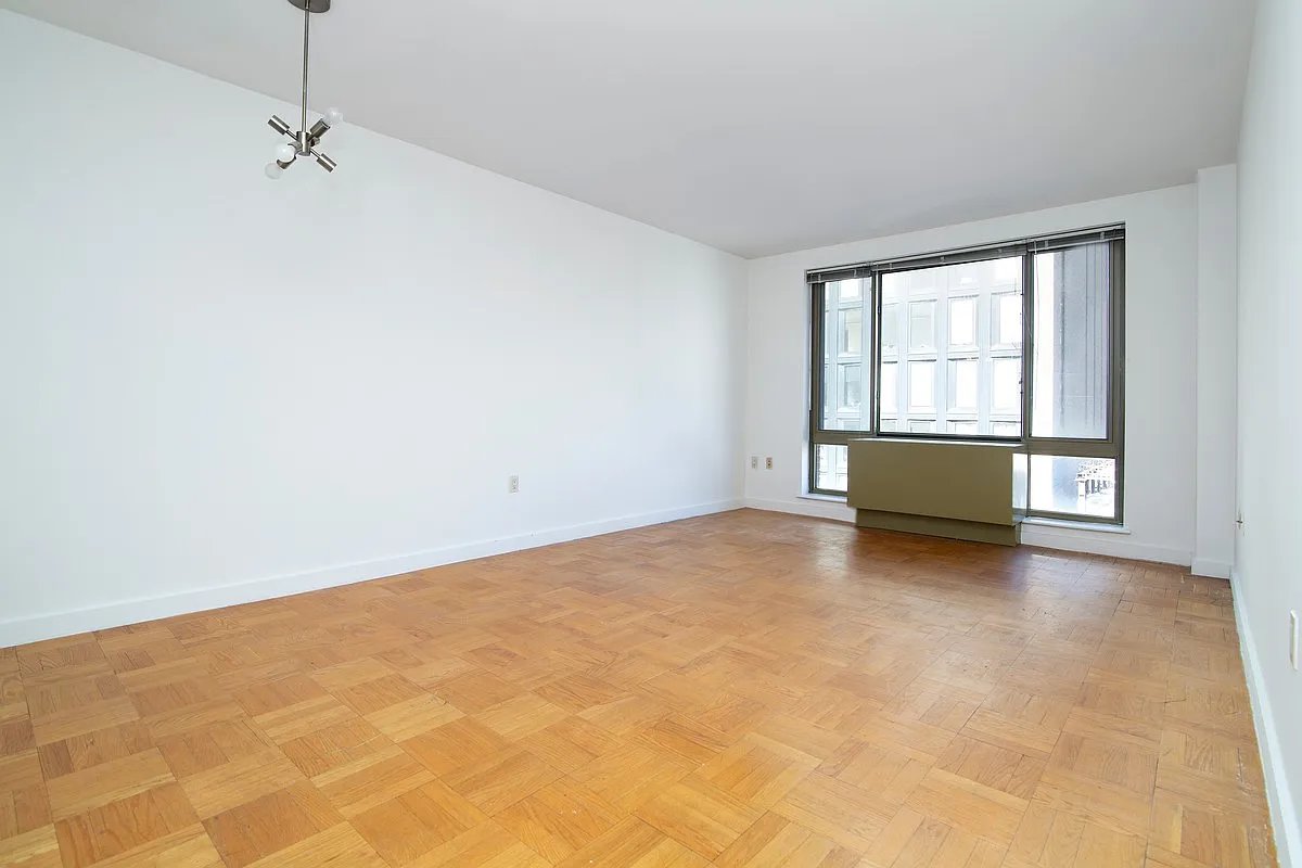 an empty room with a fireplace and windows