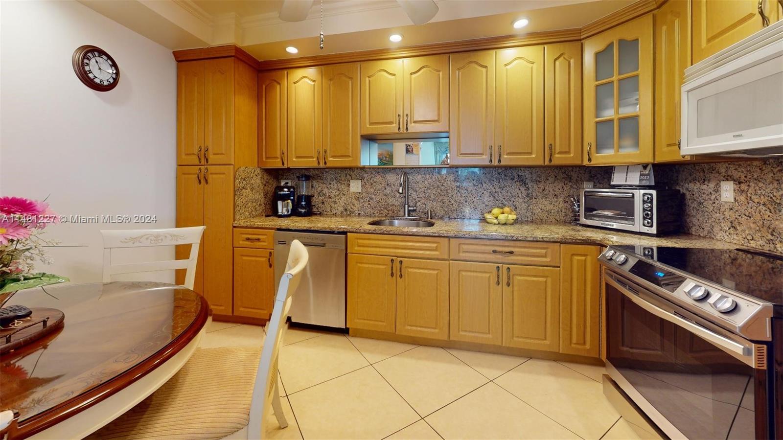 a kitchen with stainless steel appliances granite countertop a sink a stove and cabinets