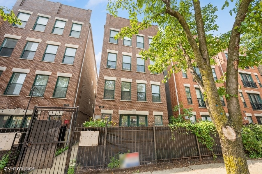 a front view of a residential apartment building with a yard