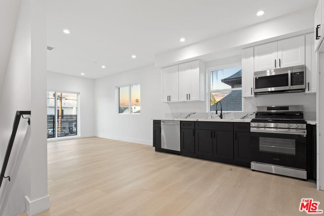 a kitchen with stainless steel appliances granite countertop a stove a sink and a refrigerator