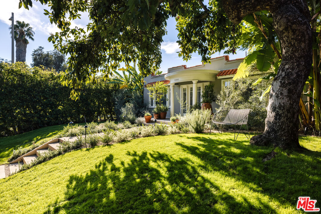 a view of a house with backyard and sitting area