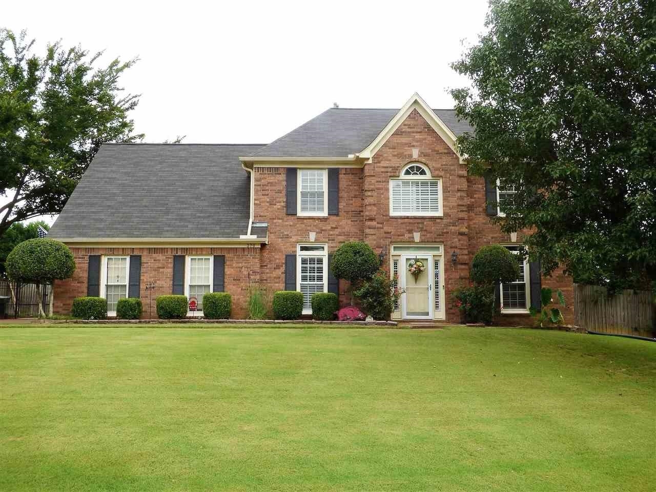 a front view of house with yard and green space