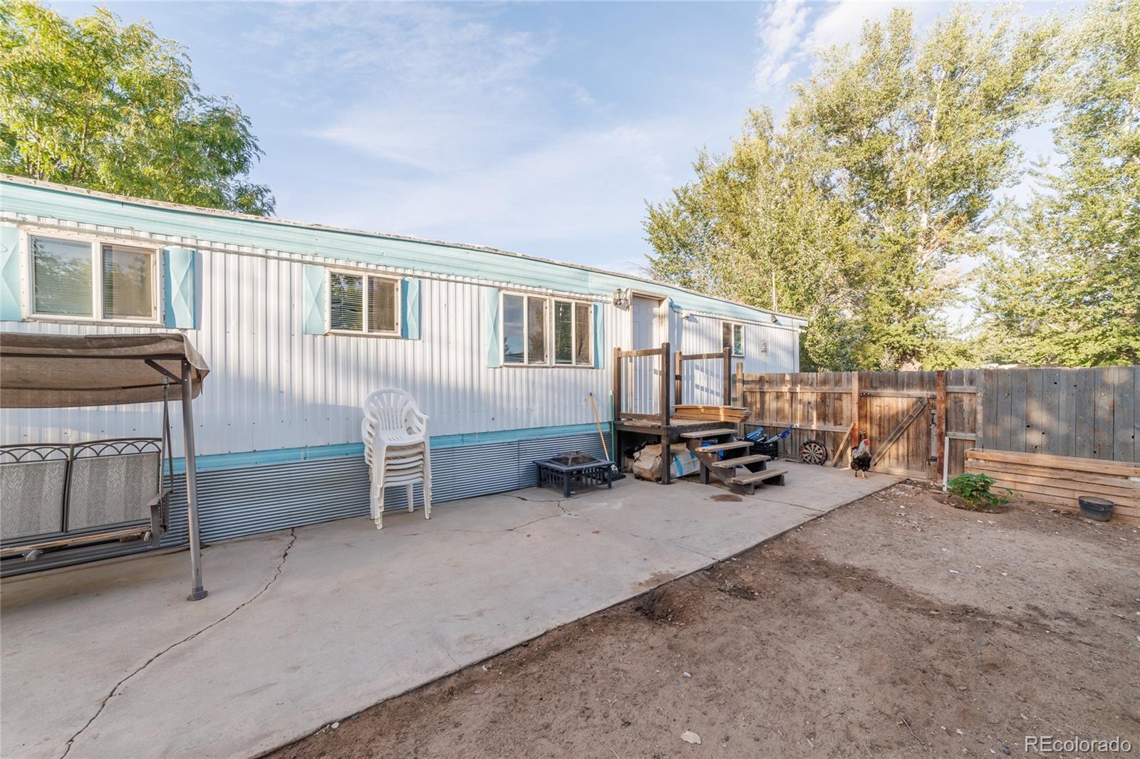 a view of a house with a patio and wooden fence