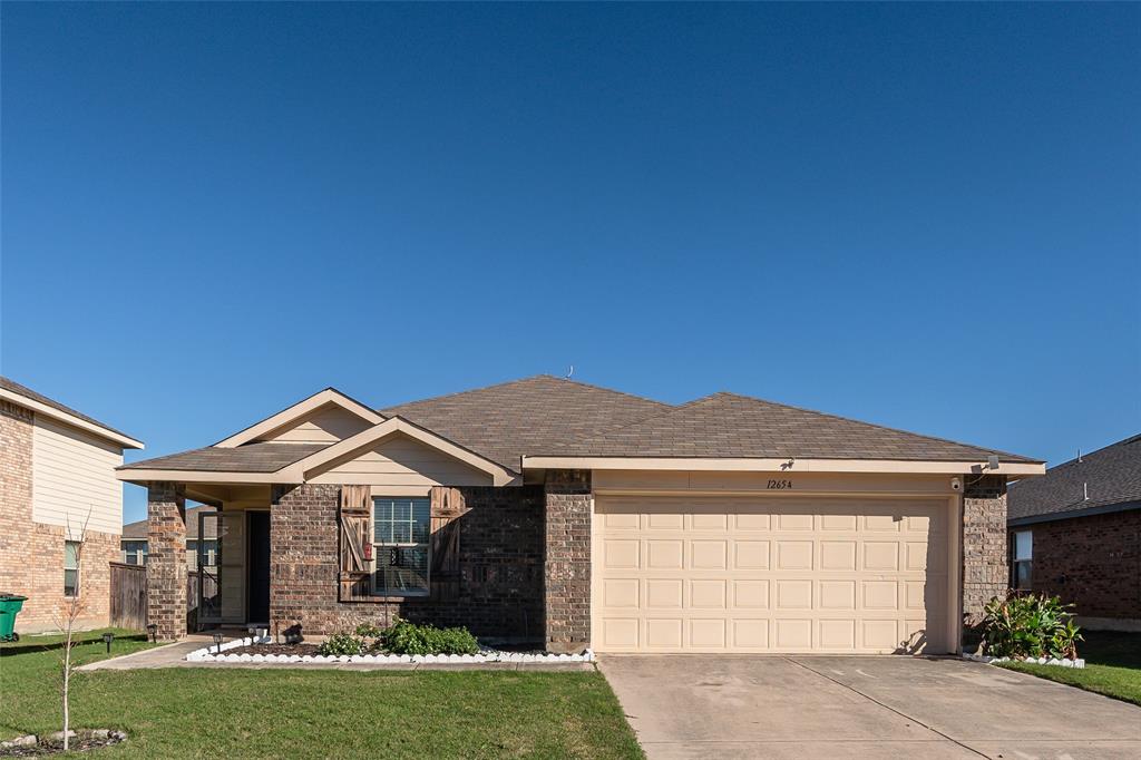 a front view of a house with a garden and yard