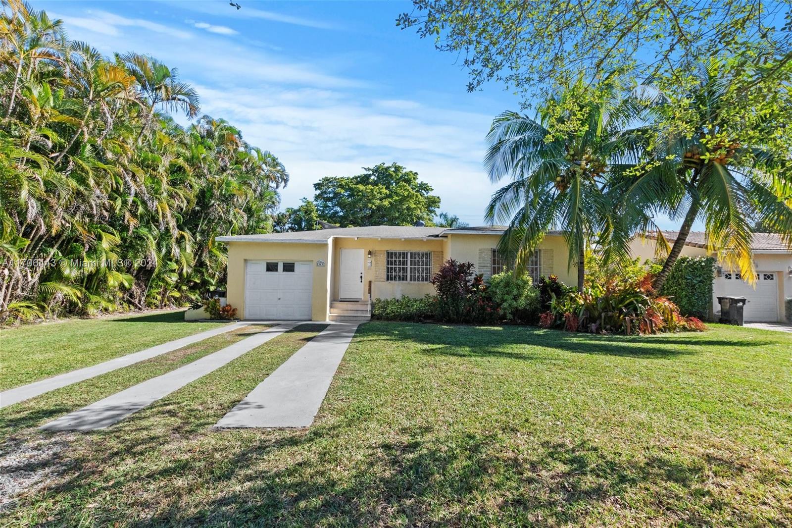 front view of a house with a yard and an trees