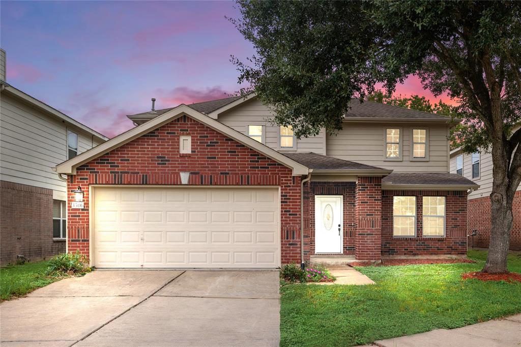 a front view of a house with a yard and garage