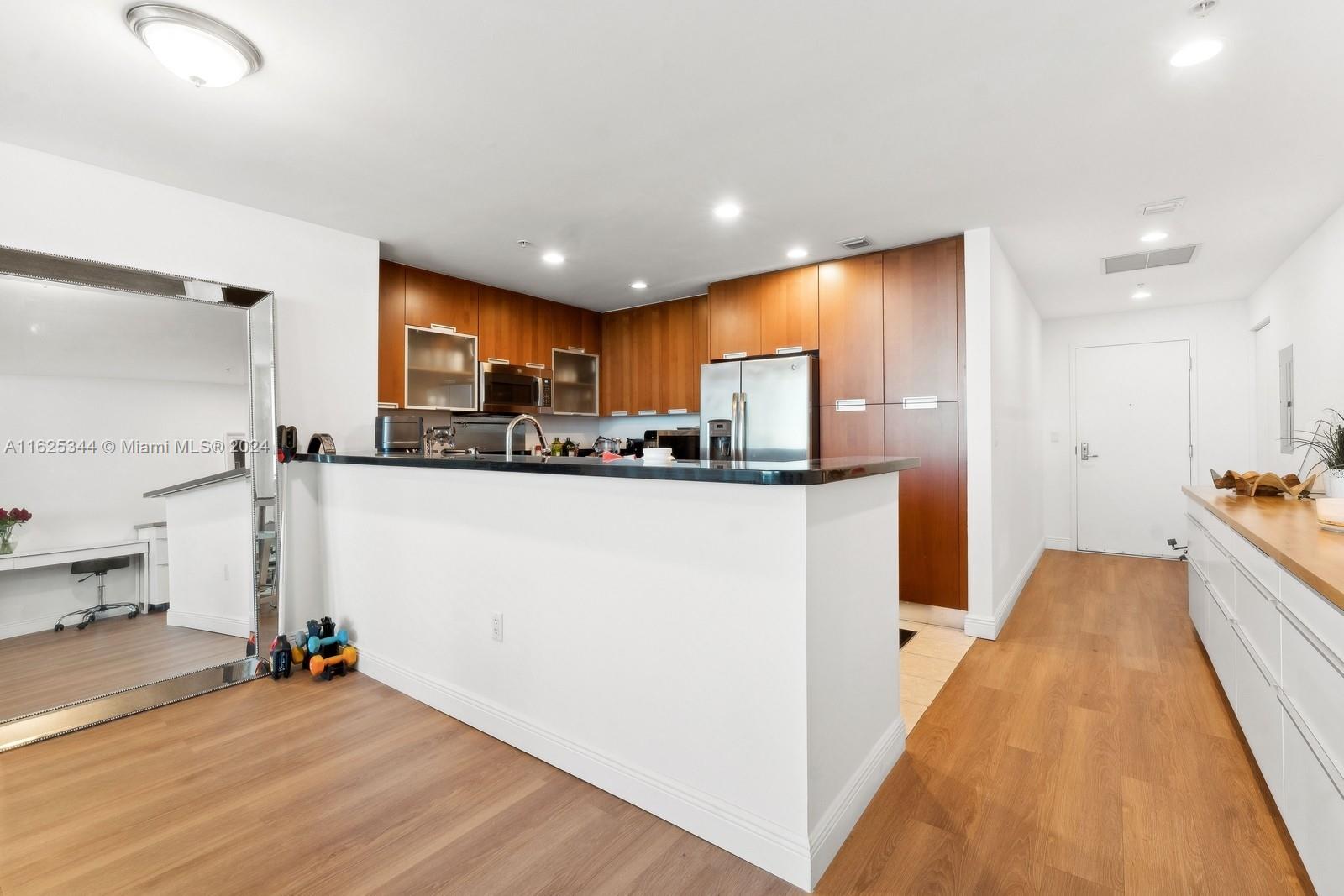 a kitchen with stainless steel appliances granite countertop a refrigerator and a stove top oven