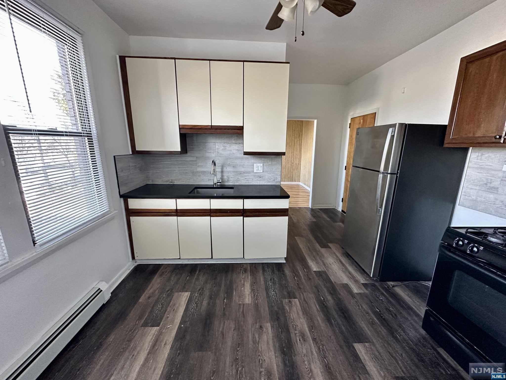 a kitchen with a sink a refrigerator and window