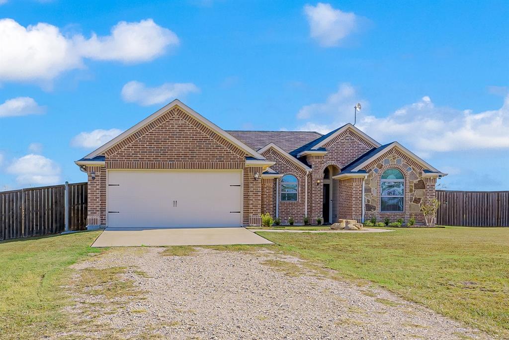 a front view of house with yard and garage