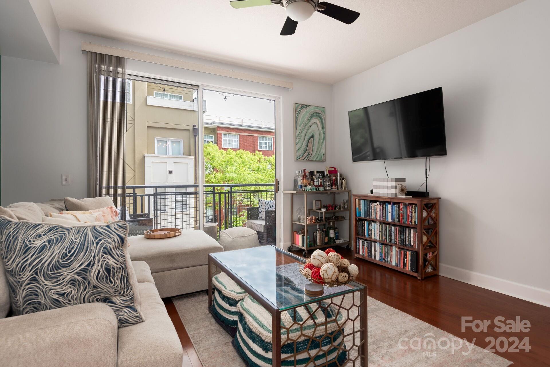 a living room with furniture a flat screen tv and a window