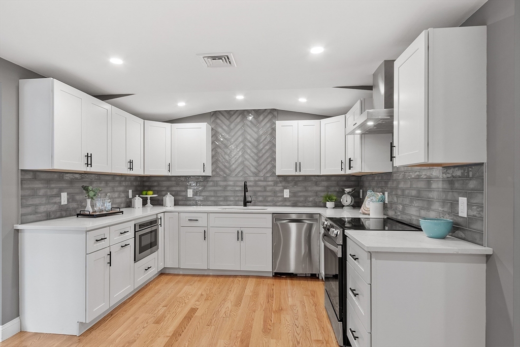 a kitchen with a sink a stove and cabinets