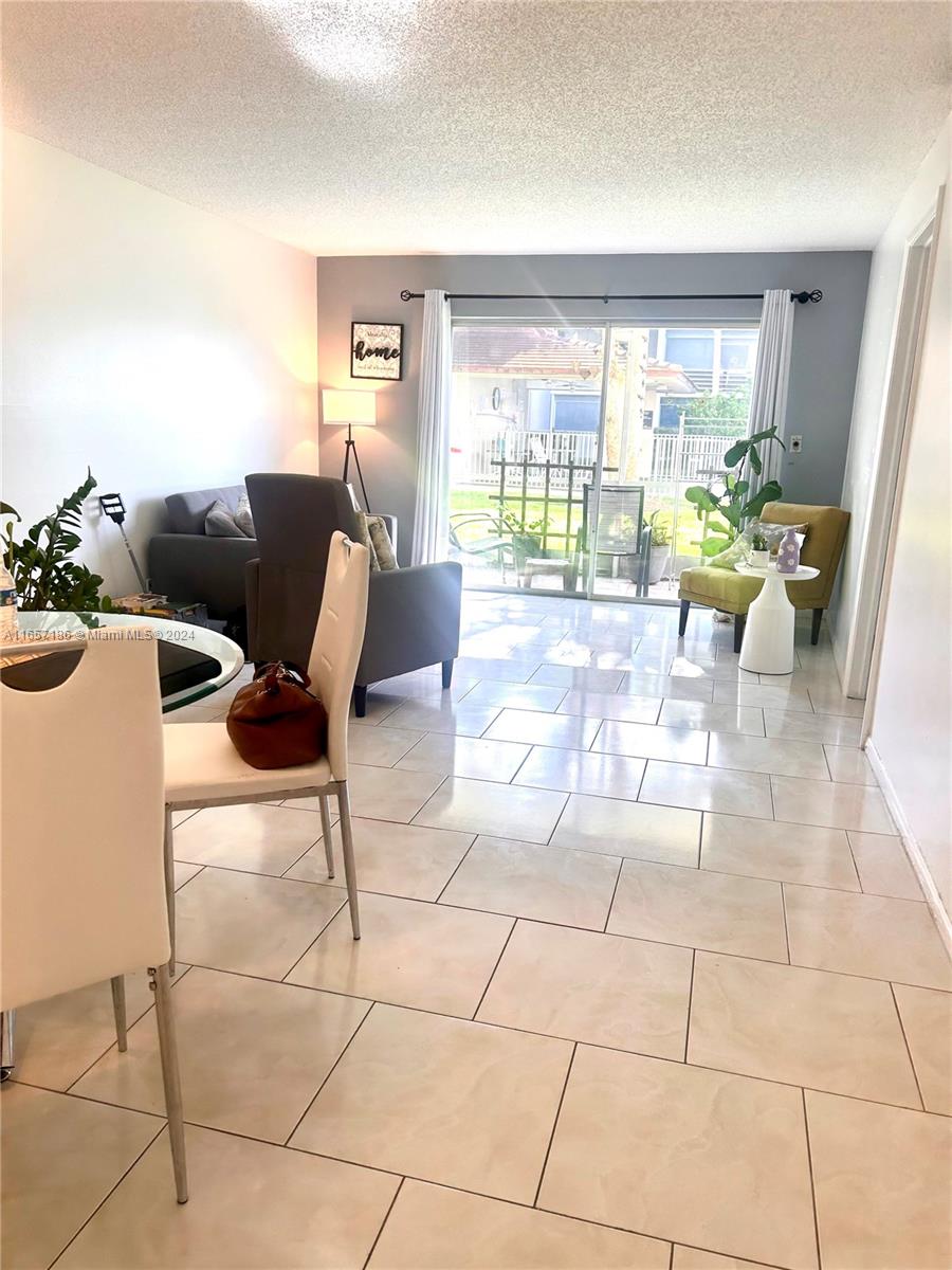 a living room with patio furniture and a potted plant