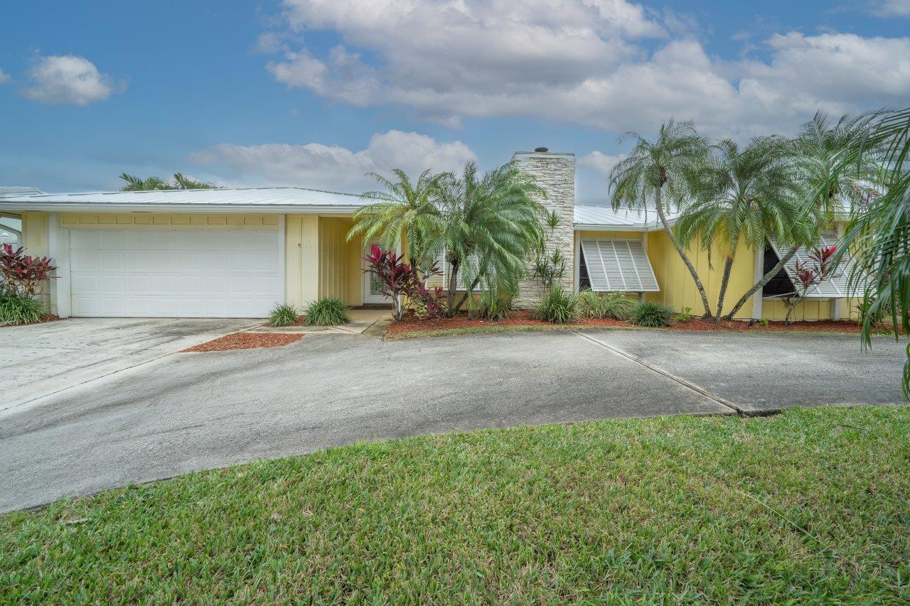 a front view of house with yard and trees around