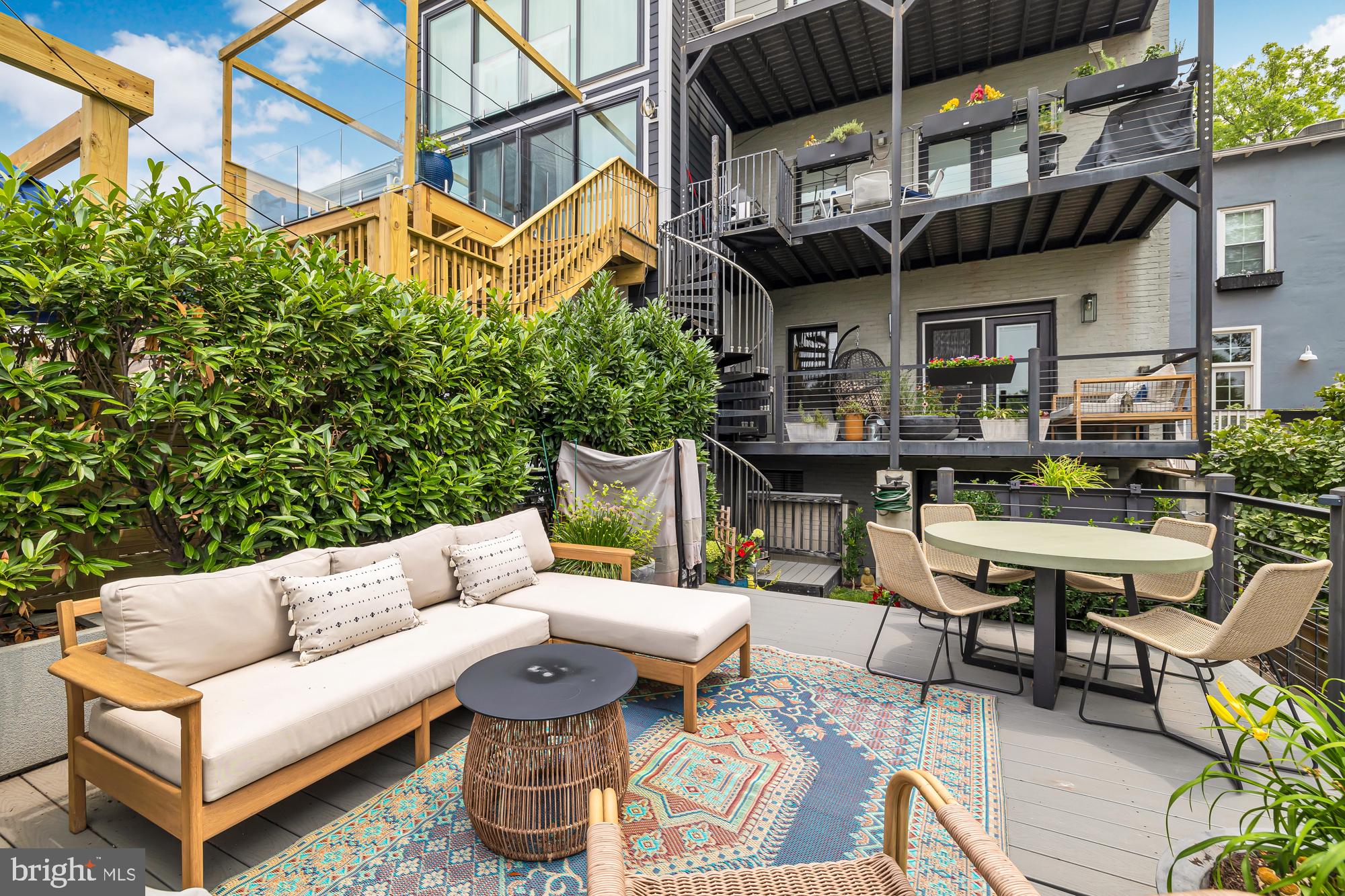 a view of a patio with couches table and chairs and potted plants